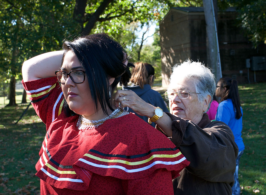 Grandmother helping granddaughter with necklace